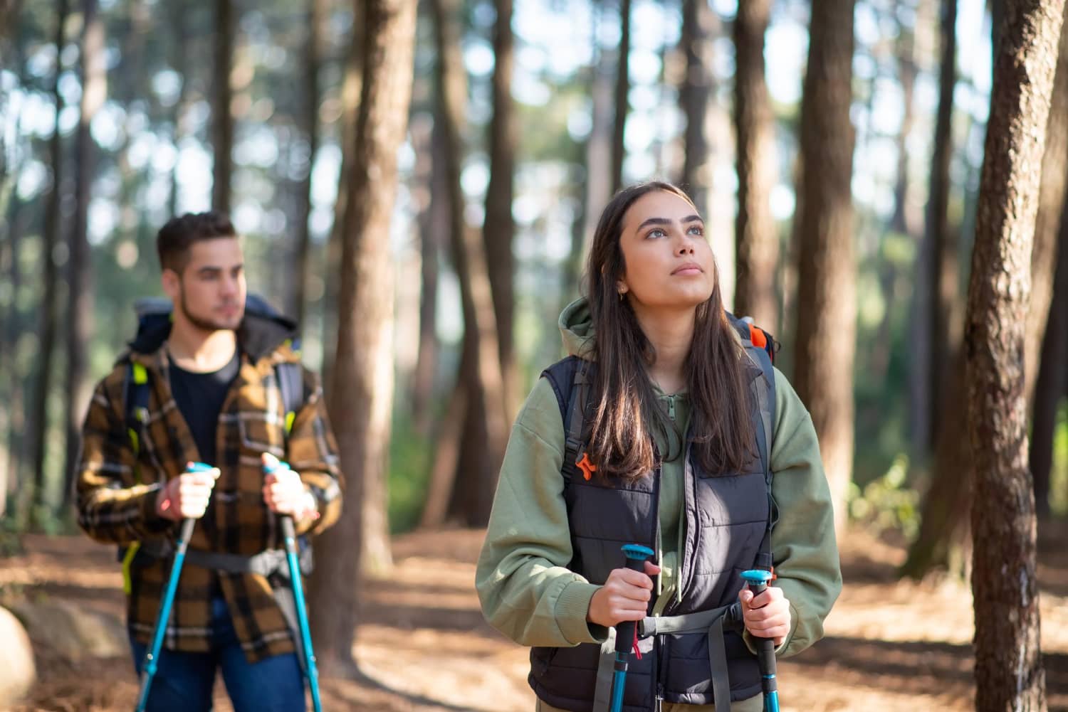Two People Hiking Through The Woods